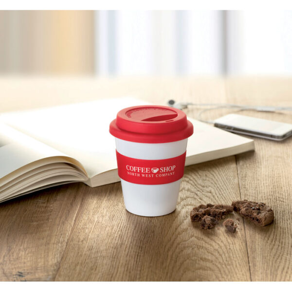 Vaso plástico reutilizable personalizado ASTORIA con tapa y banda de silicona naranja, ideal para promociones ecológicas