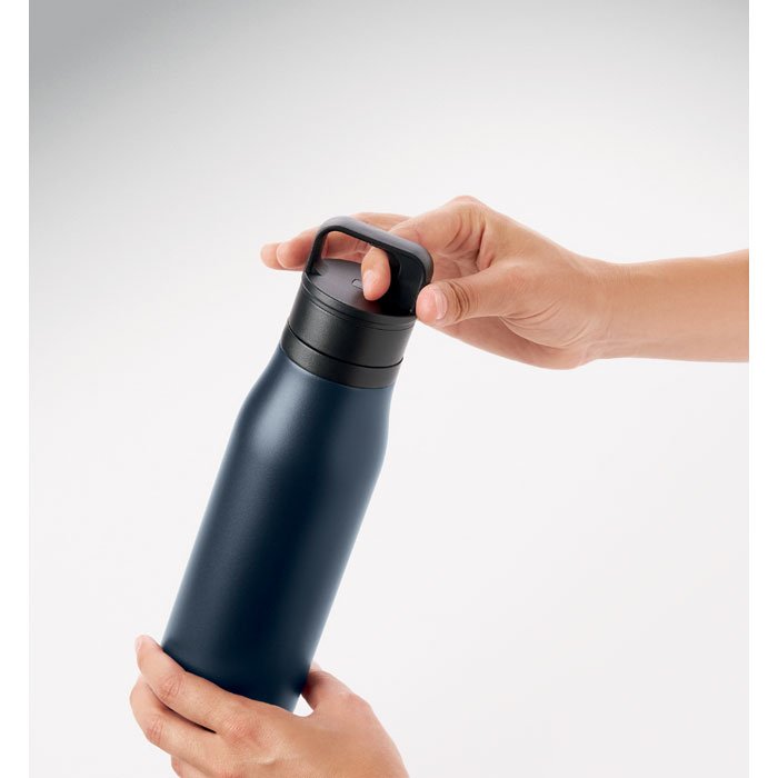 Mano sosteniendo la botella por el asa integrada de la tapa