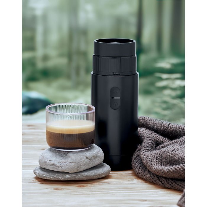 Cafetera portátil sirviendo un espresso en un vaso de vidrio